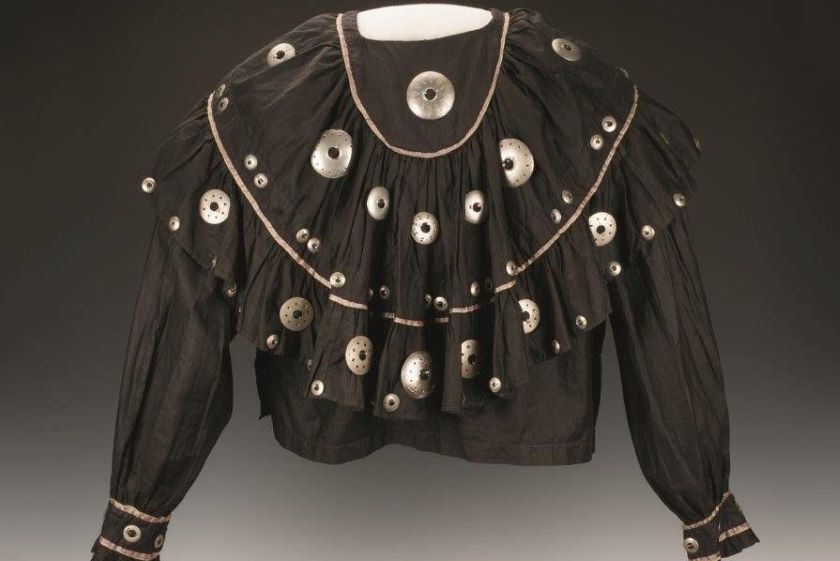 A black blouse with silver buttons on it.