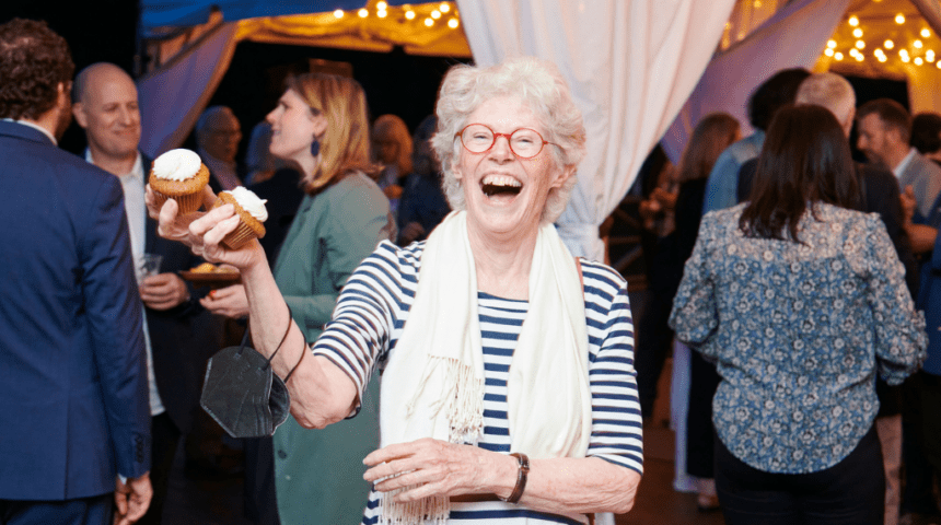 An older woman laughing at an event.