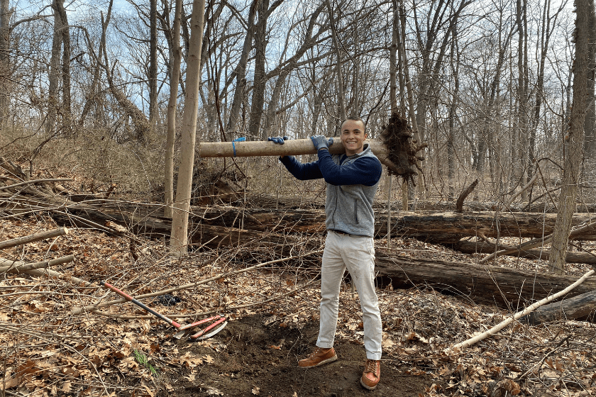 A man with a shovel in the woods.