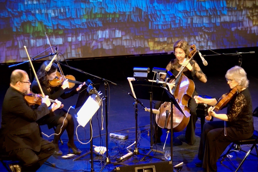 A group of people playing violin and cello on stage.