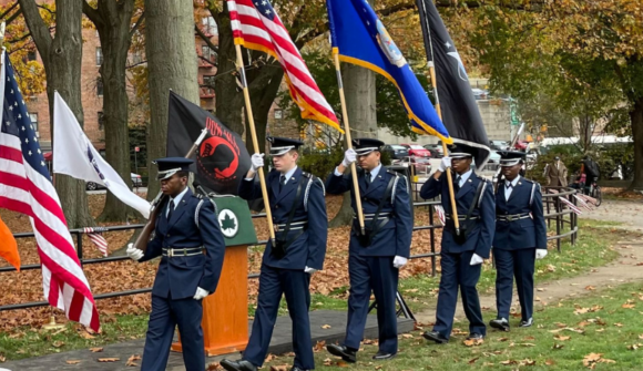 A group of air force personnel holding flags in a park.