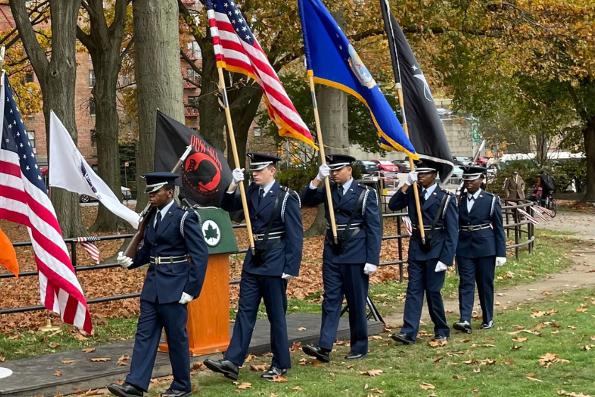A group of air force personnel holding flags in a park.