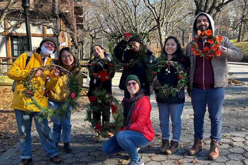 A group of people posing for a photo with wreaths.