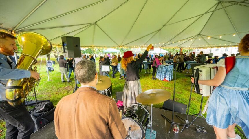 A group of people playing music under a tent.