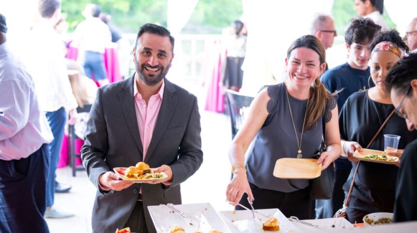 A group of people at an event with food on plates.