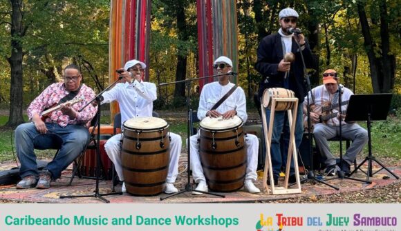 A group of 5 musicians playing drums and other instruments at an outdoor location with the words: Carbieando Music and Dance workshop with a colorful logo