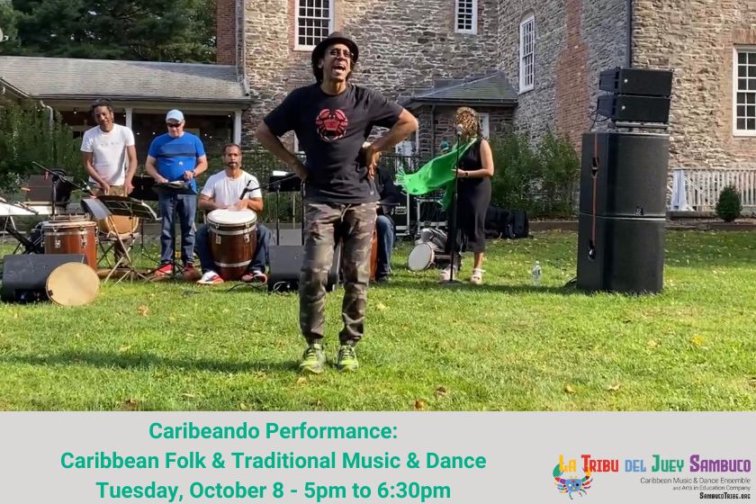 A man dancing in front of a band playing on a green lawn.