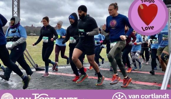 A group of people starting a race in the park with an image of a heart in a purple circle and the words Tough Love