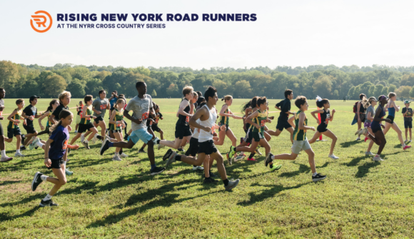 A group of young people running across a grassy field with trees in the background.